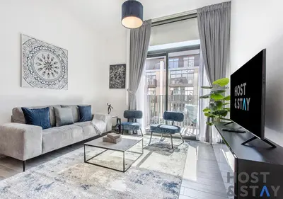 a living room with a couch and a tv at Comfy 1BR at JVC - Ideal for Family & friends in Dubai