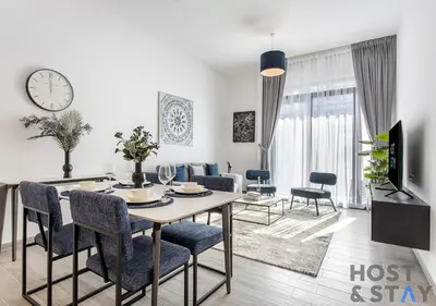 a dining room and living room with a table and chairs at Comfy 1BR at JVC - Ideal for Family & friends in Dubai