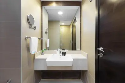 a bathroom with a white sink and a mirror at Elegant studio in Sparkle Tower by Suiteable in Dubai