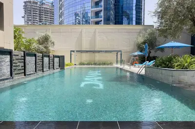 a swimming pool with blue water in a building at DAMAC APARTMENTS in Dubai