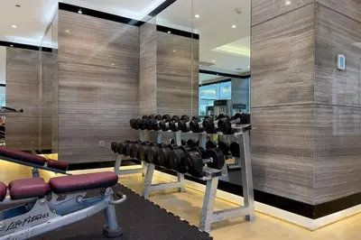 a gym with rows of dumbbells and a mirror at DAMAC APARTMENTS in Dubai