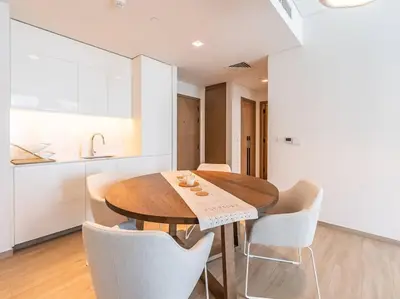 a kitchen and dining room with a wooden table and chairs at The Harbor Heights 1BR in Palace Residences Creek in Dubai
