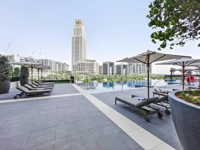 a group of lounge chairs and umbrellas on a patio at The Harbor Heights 1BR in Palace Residences Creek in Dubai