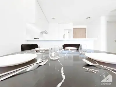 a dining table with white plates and wine glasses at Stylish 1Bedroom with Balcony & View Dubai in Dubai