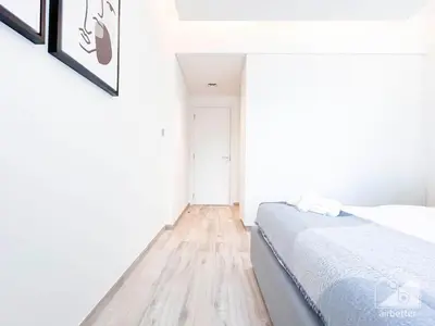 a white bedroom with a bed and a wooden floor at Stylish 1Bedroom with Balcony & View Dubai in Dubai