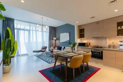 a kitchen and living room with a table and chairs at Stylish and Cozy l Park View l Next to Mall in Dubai