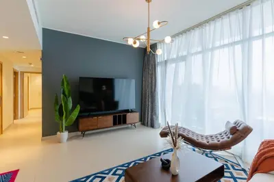a living room with a large television and a couch at Stylish and Cozy l Park View l Next to Mall in Dubai