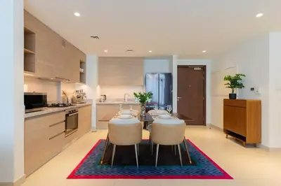 a kitchen with a dining table and a kitchen with a refrigerator at Stylish and Cozy l Park View l Next to Mall in Dubai
