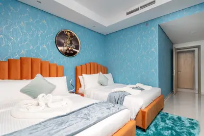 two beds in a room with blue walls at 64th-Floor Rooftop Pool with Burj Khalifa View, 2BR Apartment in Paramount Hotel Midtown in Dubai