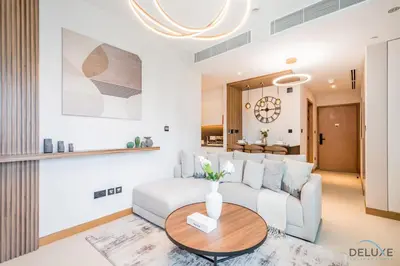 a living room with a white couch and a table at Chic 1BR in VIDA Residences Dubai Marina by Deluxe Holiday Homes in Dubai