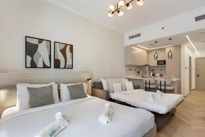 a bedroom with two beds and a living room at Marina Seaside Living prime location by the beach in Dubai