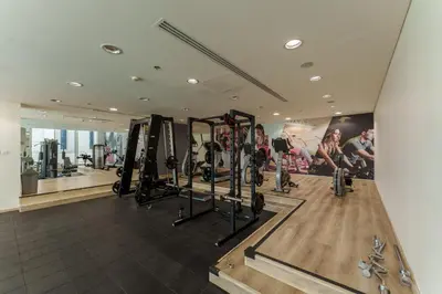a gym with tread machines and a mirror at Marina Seaside Living prime location by the beach in Dubai