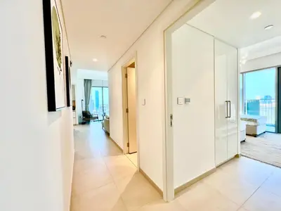 a hallway with white walls and tile floors at Downtown Views 2BR - Dubai Mall, Fountain & Burj Khalifa access in Dubai