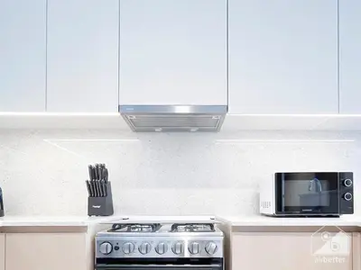 a kitchen with a stove and a microwave at Luxurious Living in 2B with Burj & Fountain Views in Dubai