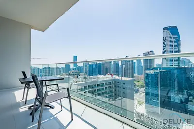 a balcony with a desk and a view of a city at Charming 1BR Apartment in Vera Tower, Business Bay by Deluxe Holiday Homes in Dubai