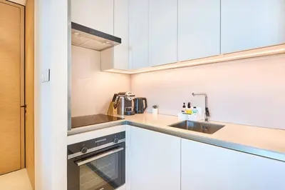 a small kitchen with white cabinets and a sink at Beachfront 1BR Retreat at Address JBR in Dubai