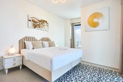 a white bedroom with a large bed and a window at Beachfront 1BR Retreat at Address JBR in Dubai