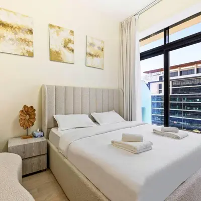 a bedroom with a large white bed with a window at Azizi Riviera 16 studio with Kitchenet - Ideal for monthly in Dubai