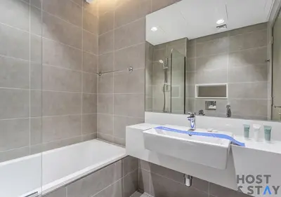 a bathroom with a tub and a sink and a shower at 1 Bedroom - Crystal Lagoon - MBR City Meydan in Dubai
