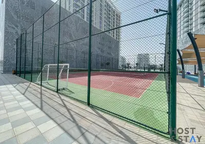 a tennis court with a net on a court at 1 Bedroom - Crystal Lagoon - MBR City Meydan in Dubai
