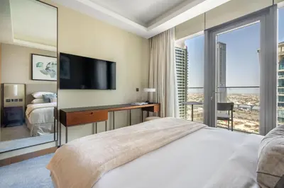 a bedroom with a large bed and a tv at GuestReady - Downtown Dubai luxurious stay in Dubai