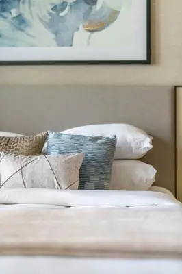 a bed with pillows and a picture on the wall at GuestReady - Downtown Dubai luxurious stay in Dubai