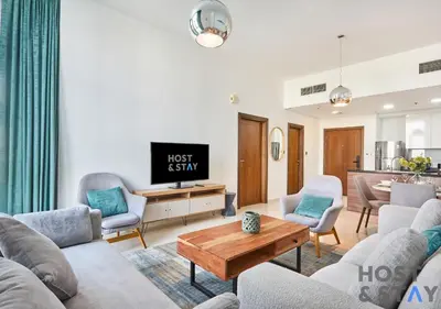 a living room with a couch and a table at Serene 1 BR in Damac Hills - Host & Stay in Dubai
