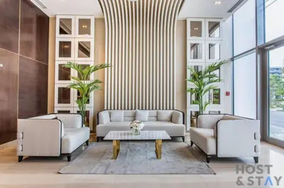 a living room with two couches and a coffee table at Lively 1 BR in Damac Hills, Dubai - Host & Stay in Dubai