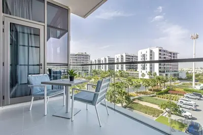 a balcony with a table and chairs and a view of the city at Lively 1 BR in Damac Hills, Dubai - Host & Stay in Dubai