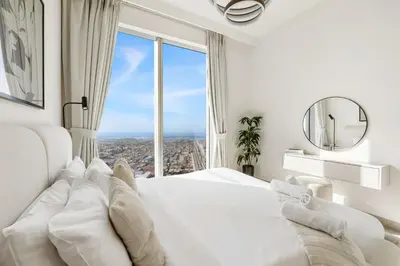 a bedroom with a white bed and a large window at Panoramic Sea View 2BR in Forte Downtown - Allsopp&Allsopp in Dubai