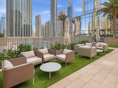 a patio with couches and tables and a city skyline at Panoramic Sea View 2BR in Forte Downtown - Allsopp&Allsopp in Dubai