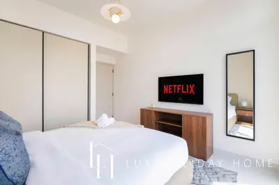 a bedroom with a bed and a tv on a wall at LUX The Marina Vista Beachfront Suite 2 in Dubai