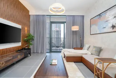 a living room with a couch and a flat screen tv at GLOBALSTAY Creek Edge Tower Elegant Apartments in Dubai