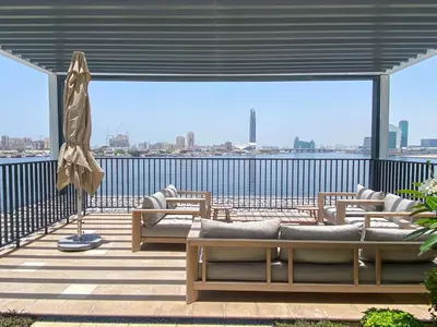 a balcony with couches and a view of the water at GLOBALSTAY Creek Edge Tower Elegant Apartments in Dubai