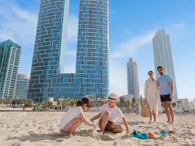 a group of people playing in the sand on the beach at Family Sky Retreat at Address Beach on 56th Floor in Dubai
