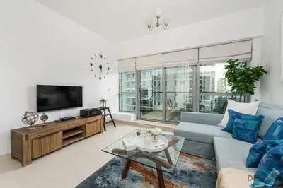 a living room with a blue couch and a tv at Charming 1BR in The Point Tower, Dubai Marina by Deluxe Holiday Homes in Dubai
