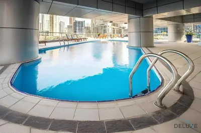 a large pool with blue water in a building at Charming 1BR in The Point Tower, Dubai Marina by Deluxe Holiday Homes in Dubai