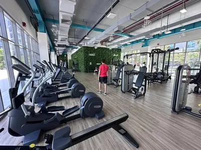 a man standing in a gym with a bunch of treadmills at Mag 510: 2-Bedroom Elegance in Dubai