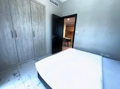 a bedroom with a white bed and a table at Mag 510: 2-Bedroom Elegance in Dubai