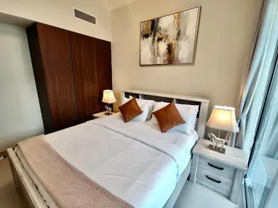 a bedroom with a bed with white sheets and pillows at Lux BnB I Vera Residences I Burj Views in Dubai