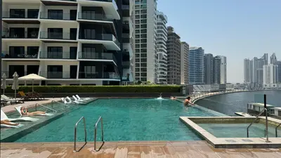a swimming pool in front of a tall building at Exclusive Canal Waterfront Views 15 Northside in Dubai