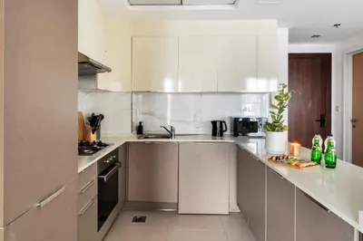 a kitchen with white cabinets and stainless steel appliances at Stella Stays Lana Tower in Dubai
