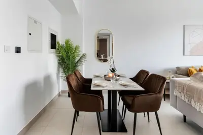 a dining room with a table and chairs and a couch at Stella Stays Lana Tower in Dubai