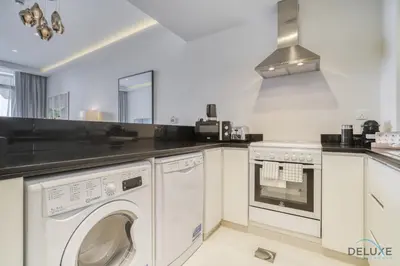 a kitchen with a washer and dryer in it at Urban 1BR at DAMAC Celestia B Dubai South by Deluxe Holiday Homes in Dubai