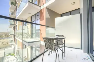 a balcony with a table and chairs in a building at Urban 1BR at DAMAC Celestia B Dubai South by Deluxe Holiday Homes in Dubai