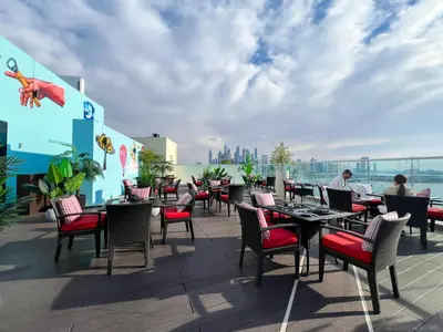 a patio with tables and chairs on a roof at Luxurious Sea-View Studio in Seven Palm - 20AB8 in Dubai