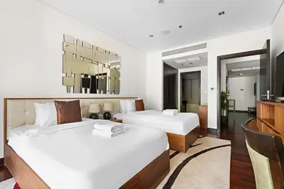 two beds in a room with white walls at StoneTree - Luxury 2 BR - Beach Access in Dubai