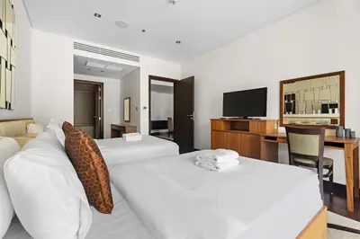 a hotel room with two beds and a television at StoneTree - Luxury 2 BR - Beach Access in Dubai