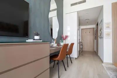 a kitchen with a dining table with chairs and a tv at Frank Porter - Riviera 27 in Dubai