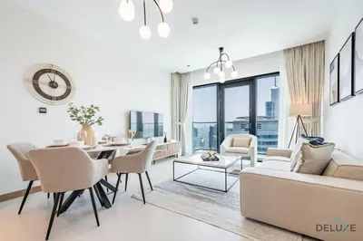 a living room with a couch and a table and chairs at Delightful 2BR Apartment in VIDA Residences Dubai Marina by Deluxe Holiday Homes in Dubai